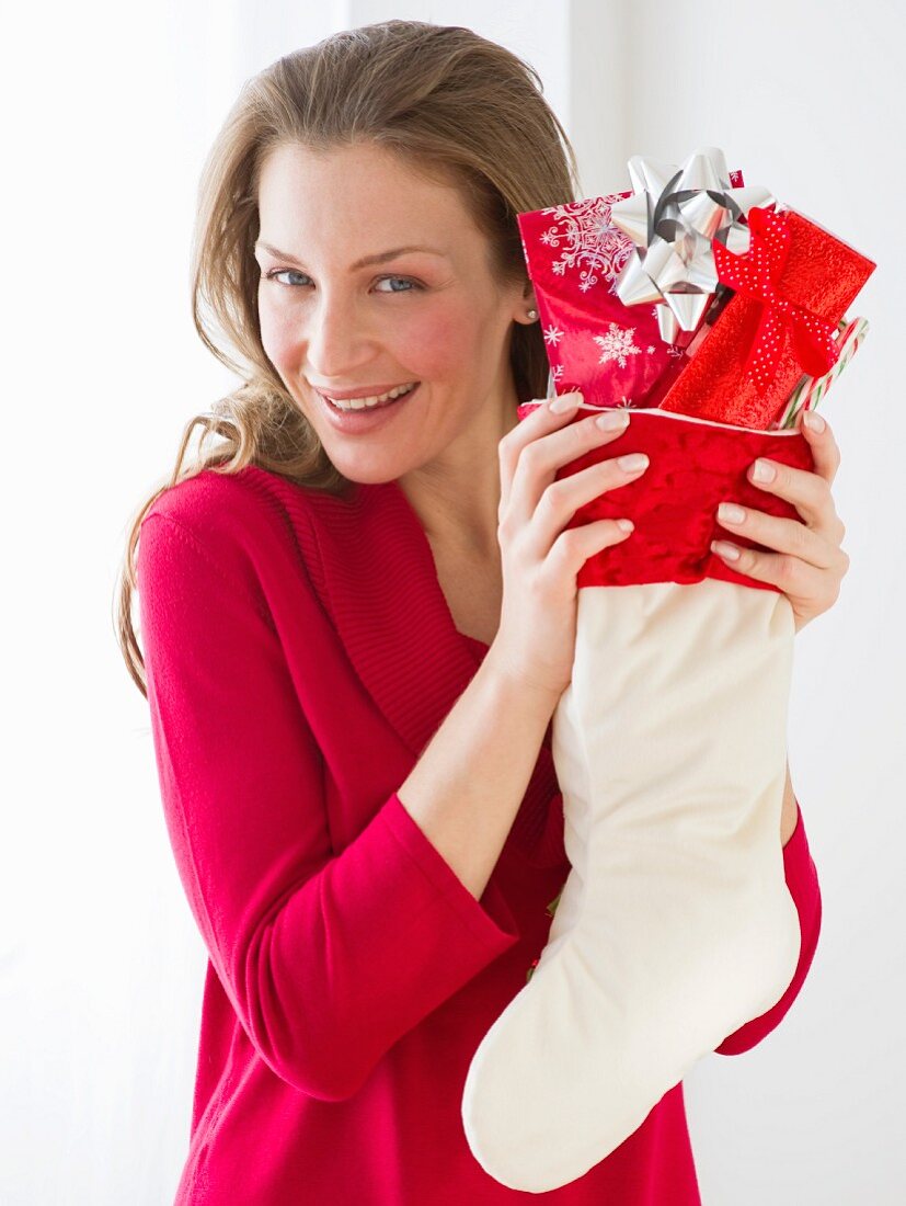 Frau hält Stiefel mit Weihnachtsgeschenken