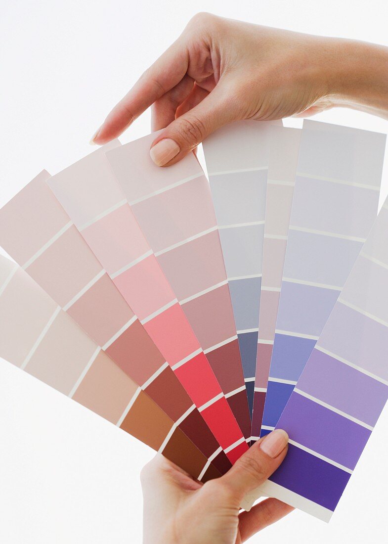 Close up of woman comparing paint swatches