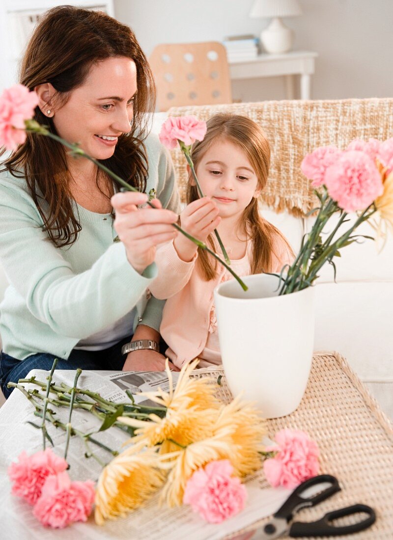 Mother and daughter making flower arrangement