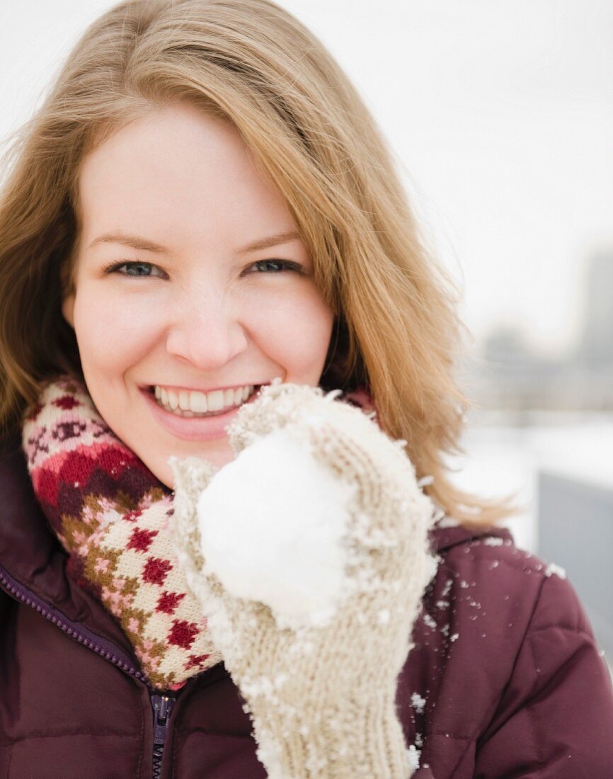 Junge Frau mit einem Schneeball