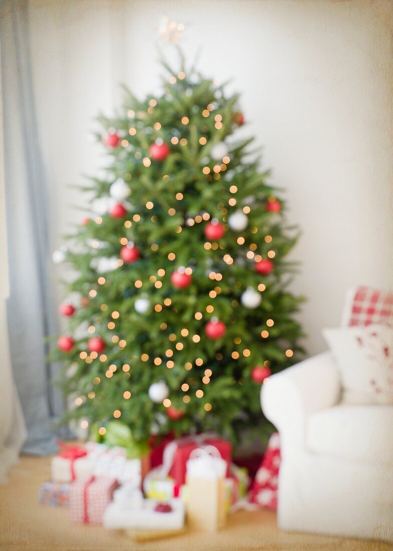 Dekorierter Weihnachtsbaum & Geschenke neben Sofa