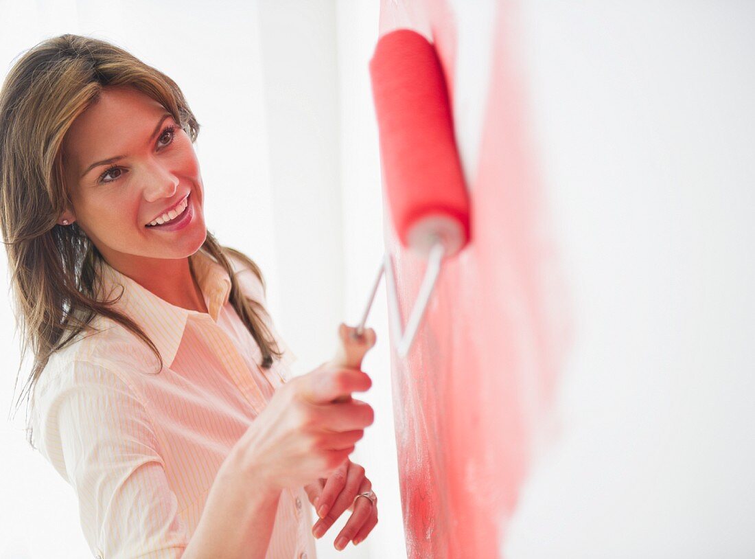 Woman painting wall with rollerpaint