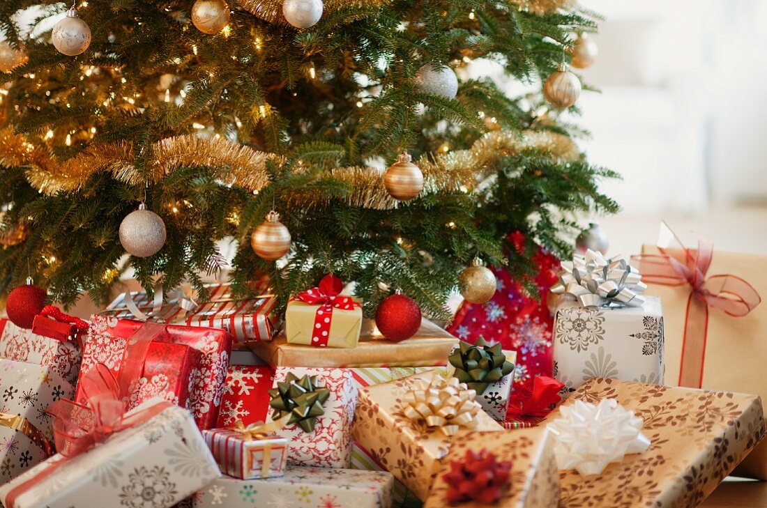 Geschmückter Weihnachtsbaum mit gestapelten Weihnachtsgeschenken