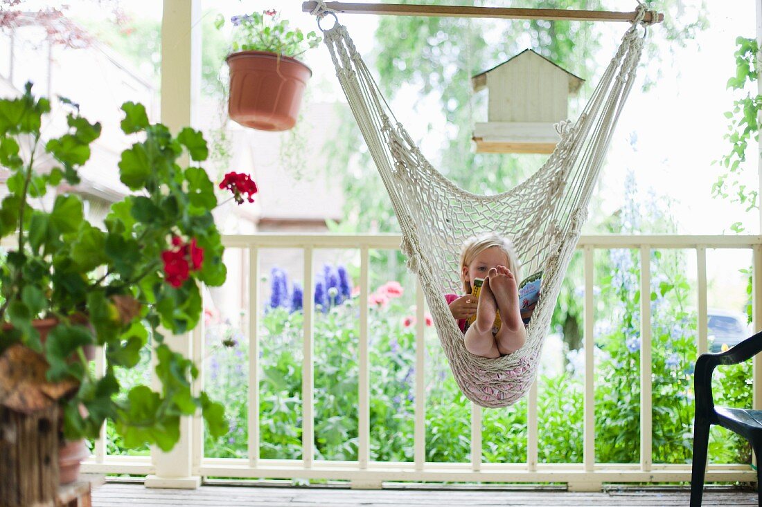 Young girl reading in hammock