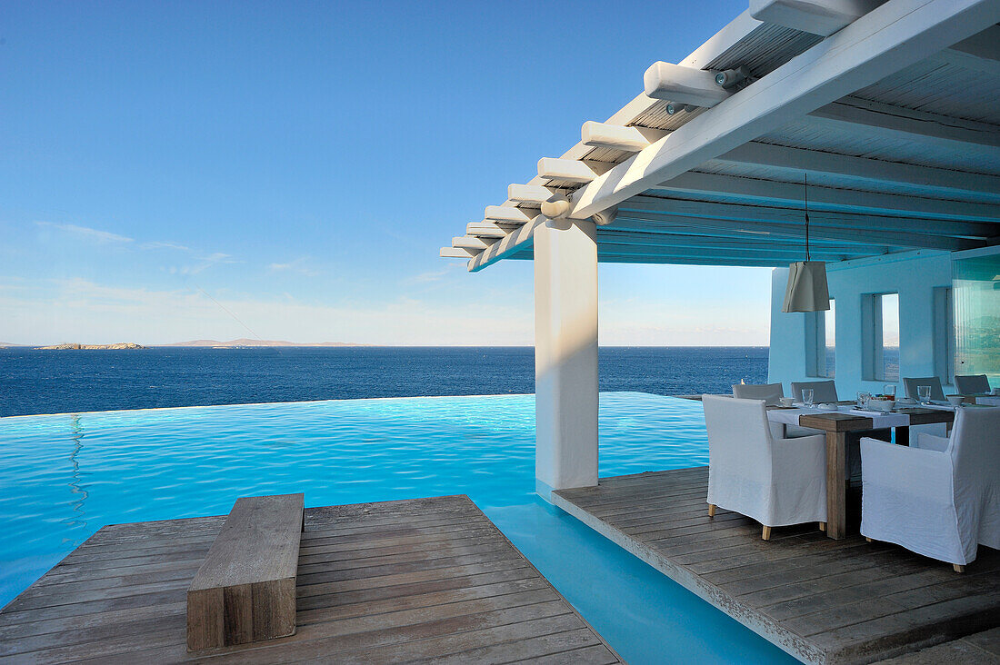 Set tables on floating wooden deck next to pool with view of ocean