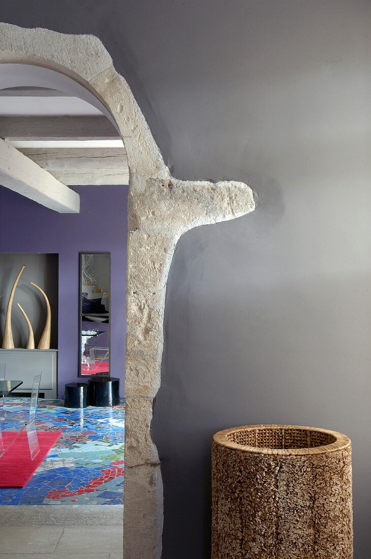 Rundbogen mit Steineinfassung und Blick in modernes, farbenfrohes Wohnzimmer