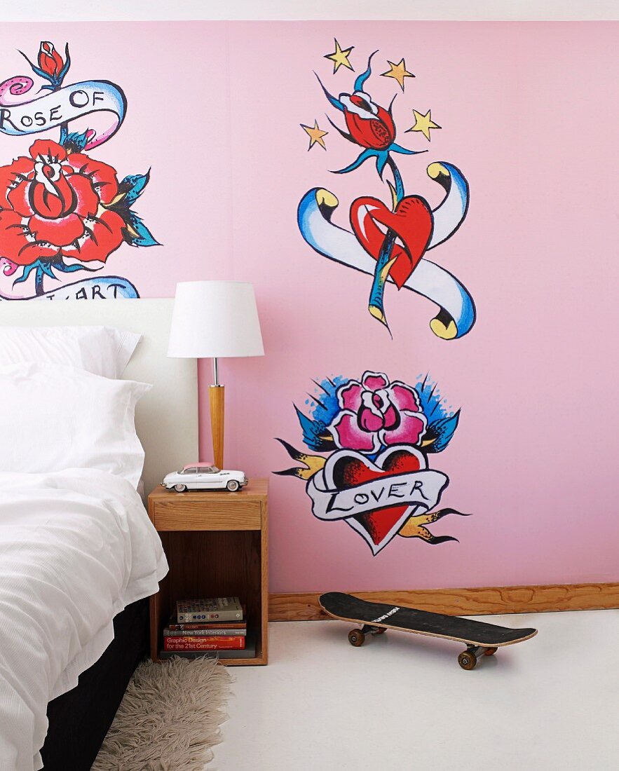 Girl's bedroom with tattoo murals and skateboard next to bedside table