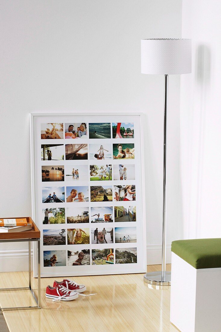 Weiß gerahmte Fotocollage mit Familienfotos in Zimmerecke mit weisser Stehlampe