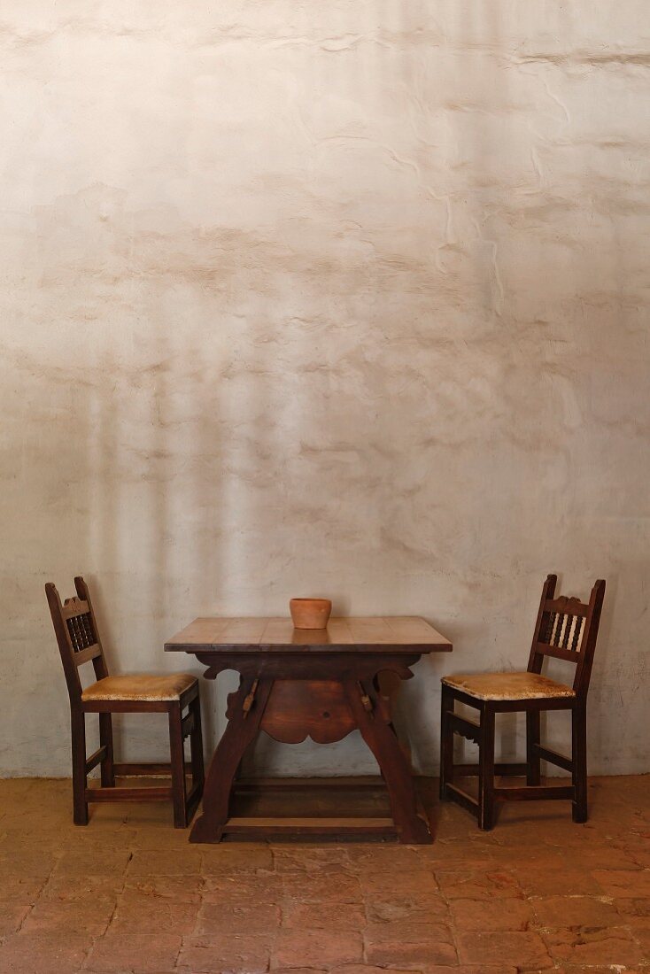 Tisch mit Stühlen in einem Zimmer mit Lehmziegelwänden in der Mission La Purisima State Historic Park, Lompoc, Kalifornien