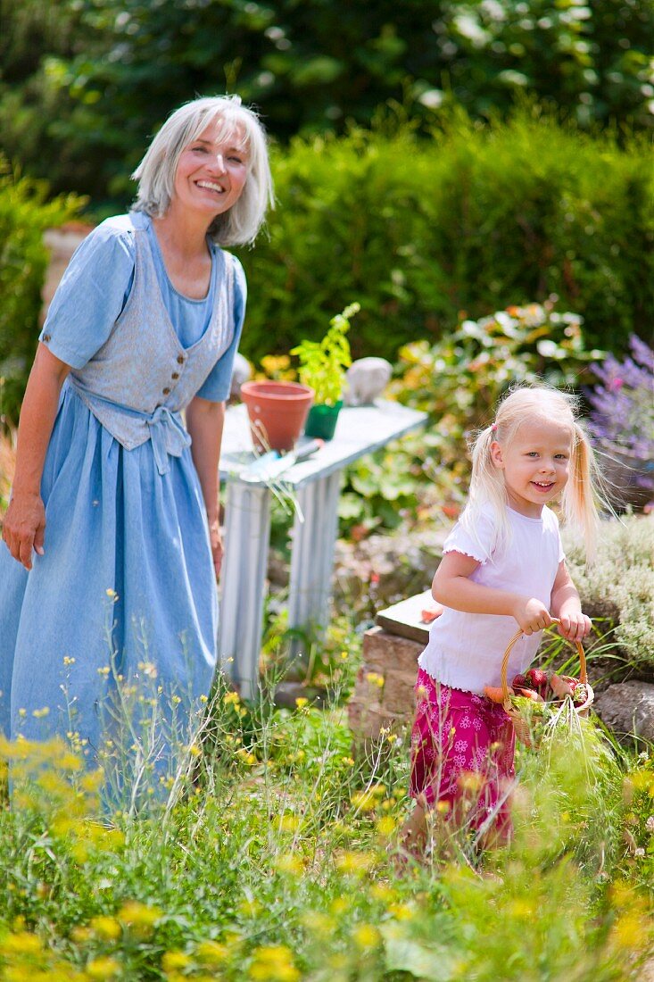 Germany, Bavaria, Mature woman with girl in garden