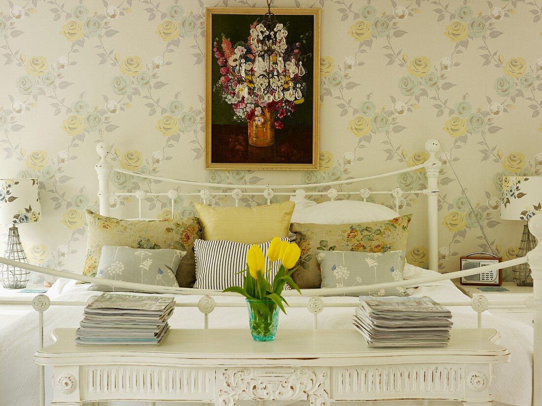 Romantisches Schlafzimmer mit Nachttischchen, Blumentapete und Blumenbild