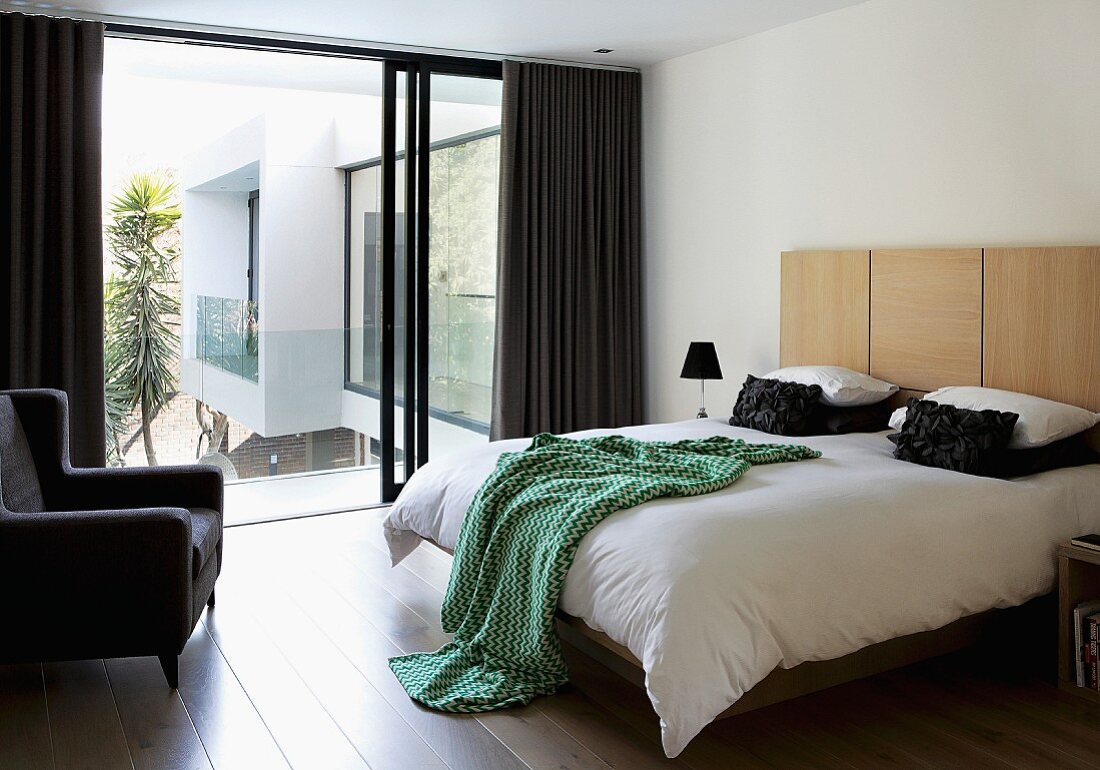 Double bed with wooden headboard in elegant bedroom