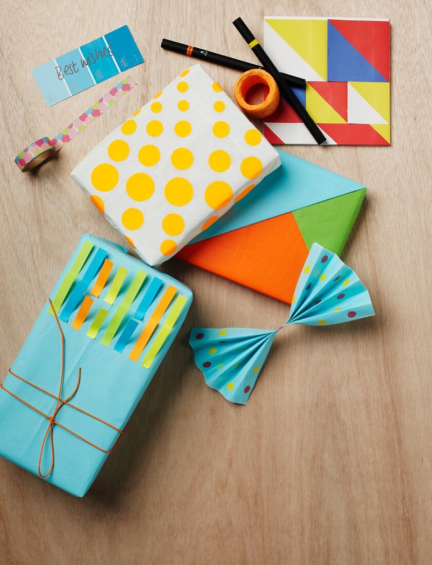 Mit Selbstklebepunkten und farbigen Memostreifen verzierte oder im Tangramstil kunstvoll arrangierte Geschenkpäckchen