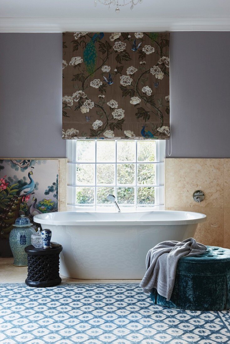 Wandbild mit Vogelmotiv und chinesische Porzellanvase neben freistehender Badewanne unter Sprossenfenster in hellem Badezimmer