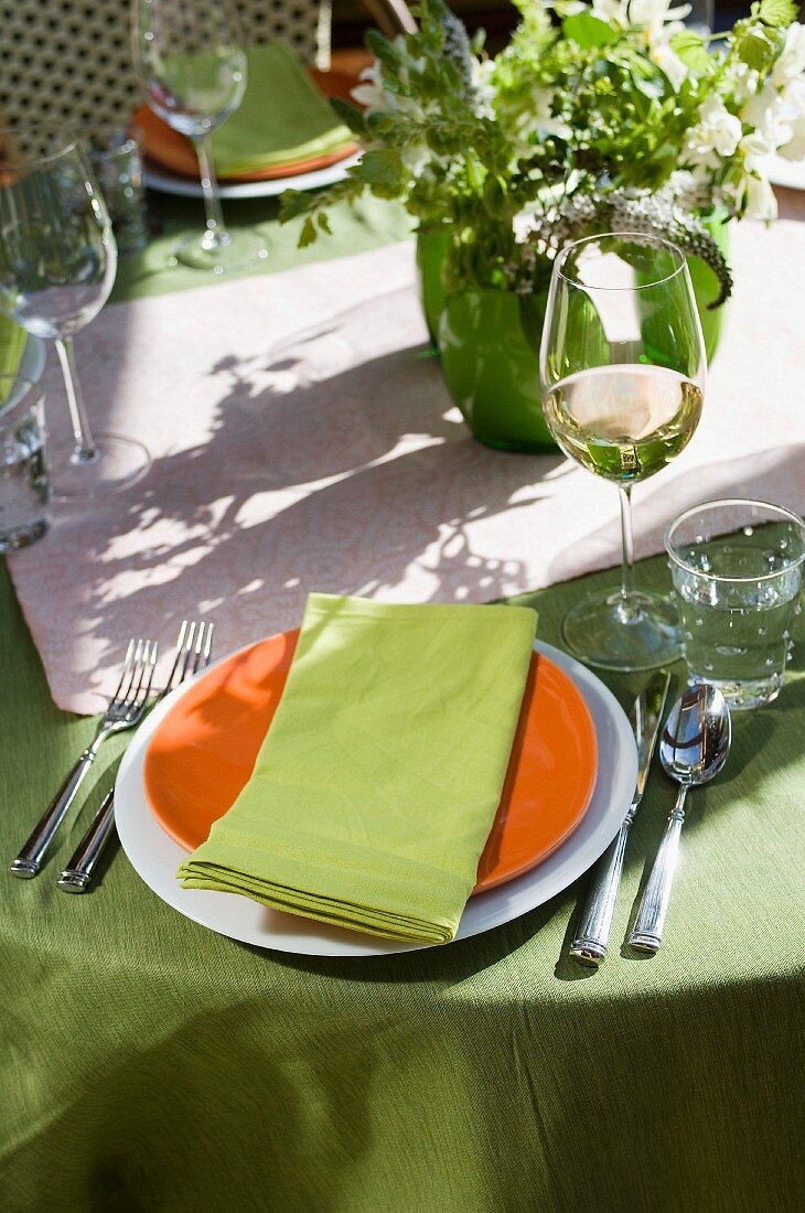 Gedeckter Tisch mit Weissweinglas im Freien
