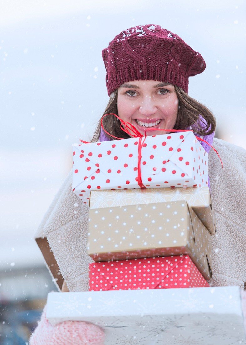 Woman carrying stack of Christmas presents