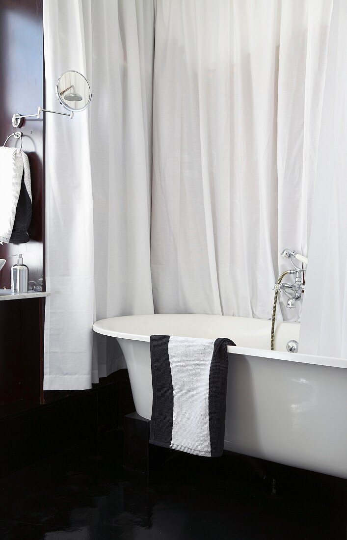 Badezimmer in Schwarzweiss mit Badewanne und Duschvorhang