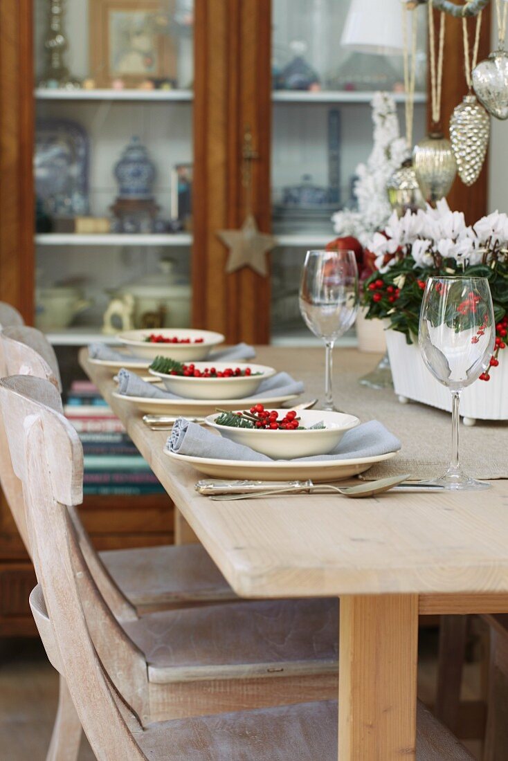 A table laid for Christmas next to a glass-fronted cabinet