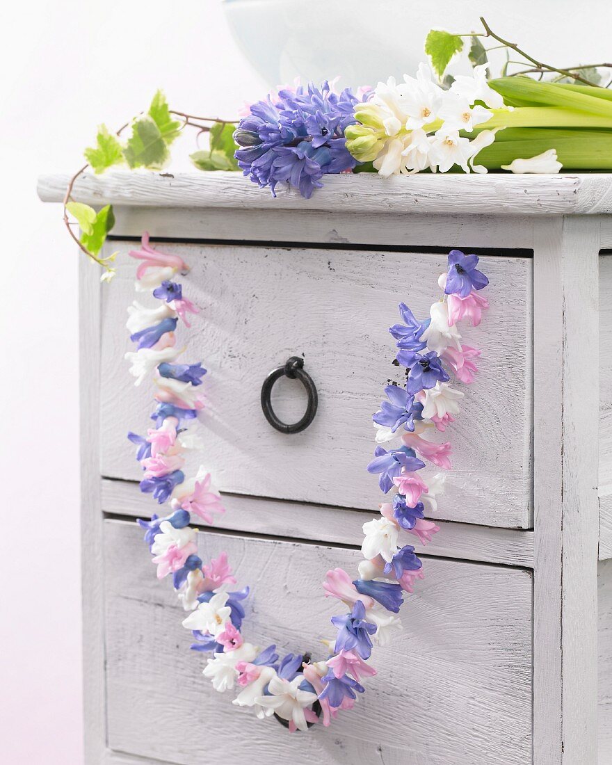 Vintage chest of drawers decorated with garland of hyacinth florets
