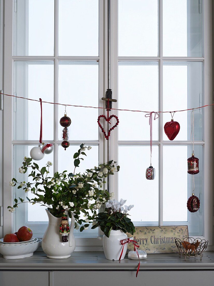 Blumen in Vintage Vasen auf Fensterbrett mit Weihnachtsdekoration