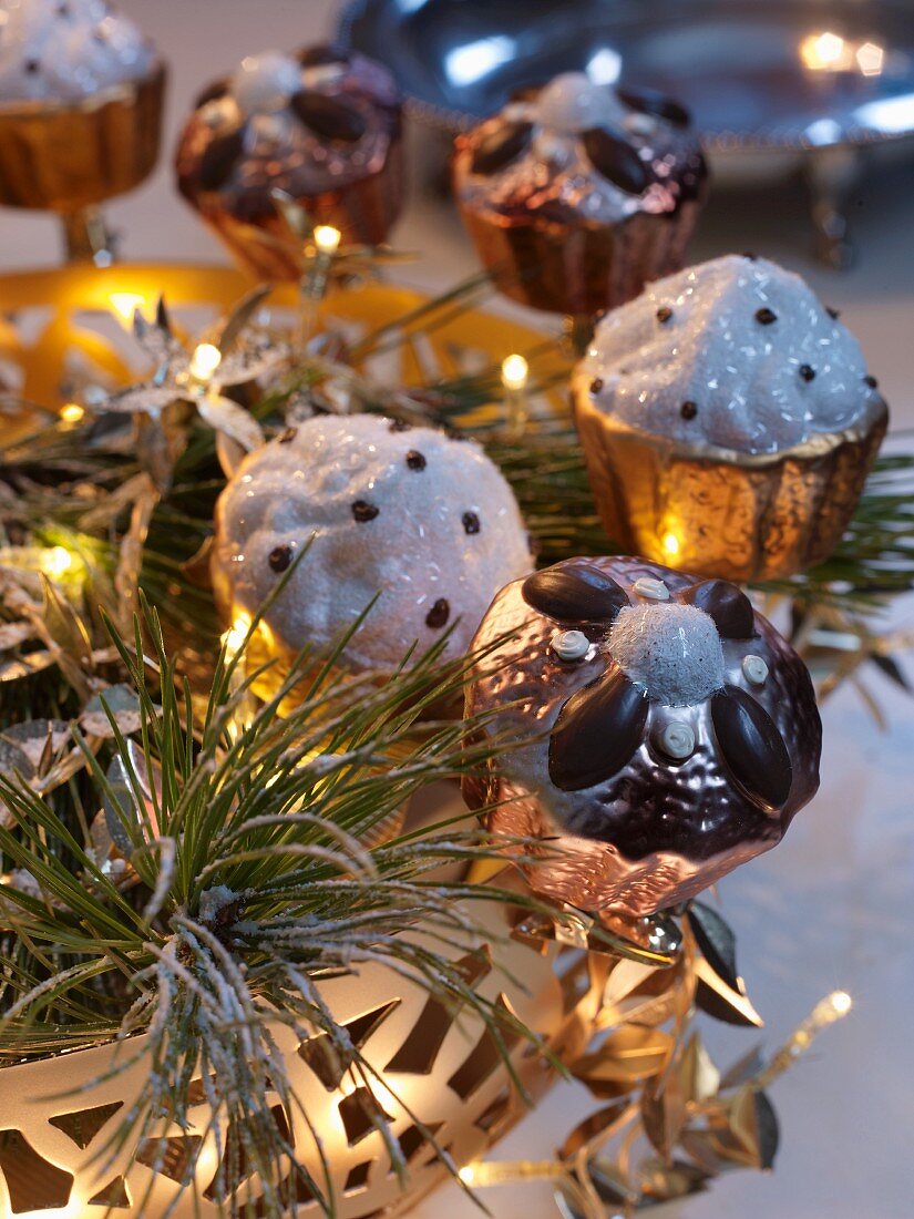 Metal, cake-shaped decorations on brass tray with fairy lights