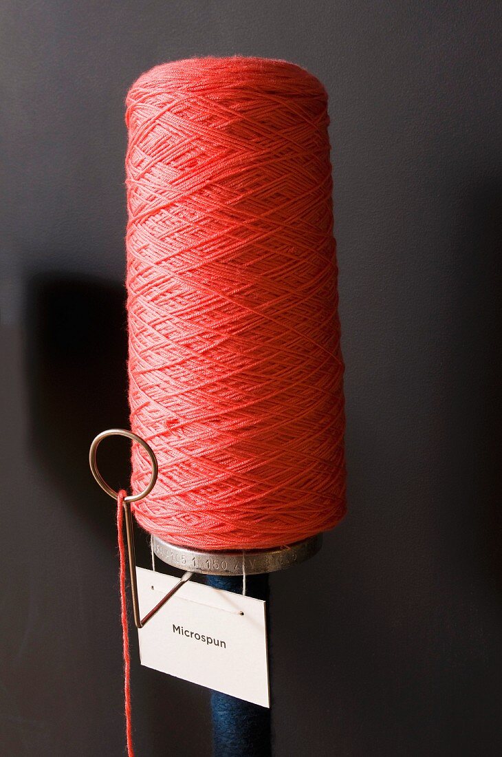 Bobbin of red yarn with label