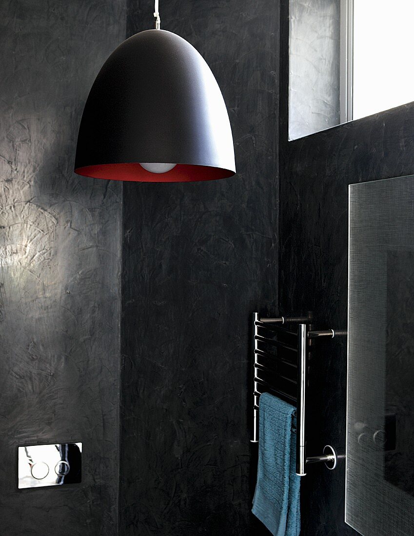 Black and red pendant lamp against dark, marbled bathroom walls