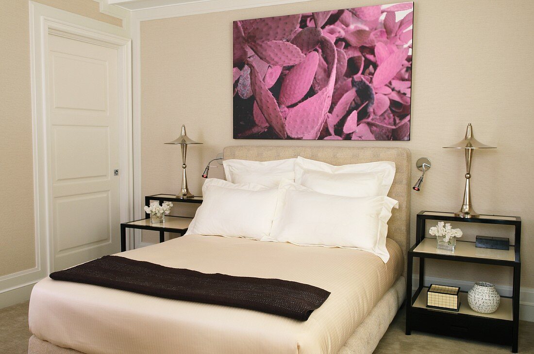 Double bed with upholstered headboard below modern photograph in classic, sand-coloured bedroom