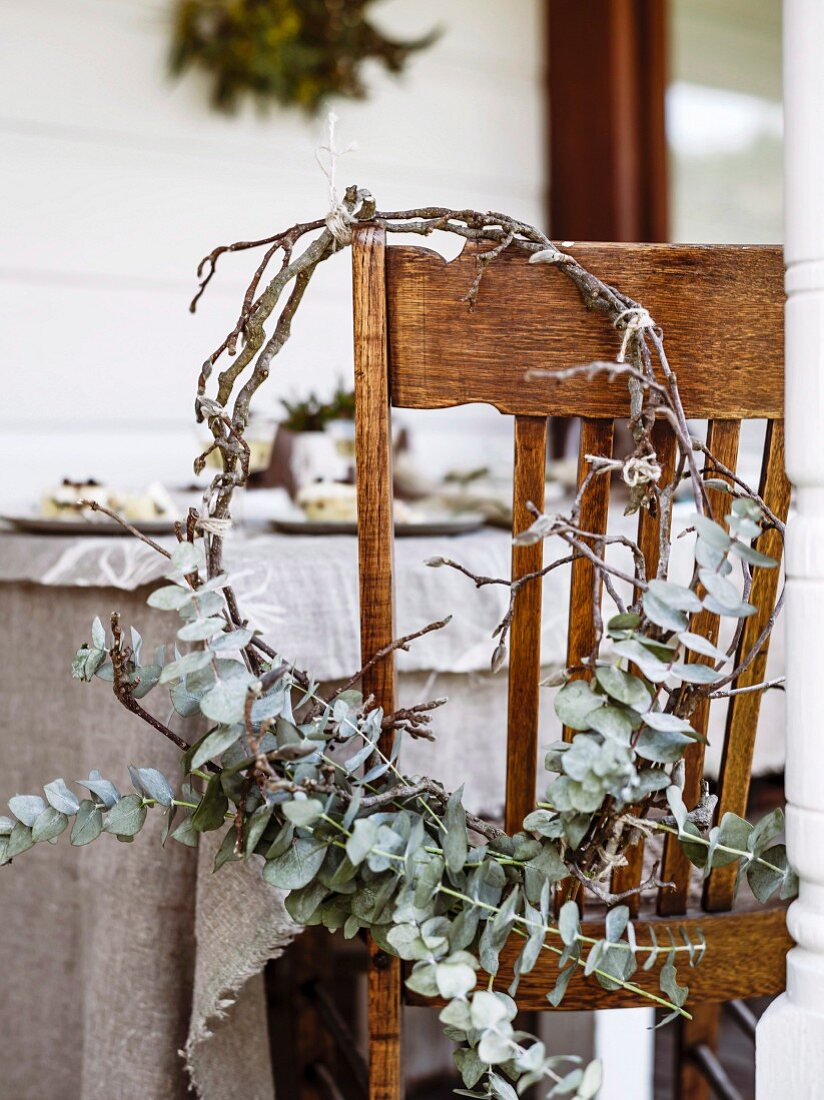 Wintery wreath of twigs and leaves on chair on veranda