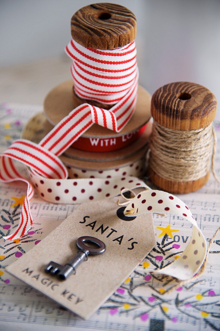 Key on labelled tag; ribbons and yarn on vintage wooden reels