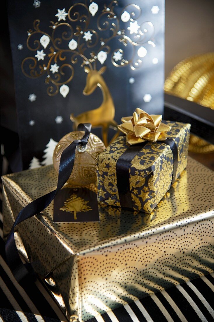 Verpackte Weihnachtsgeschenke mit Papier in Blau und Gold
