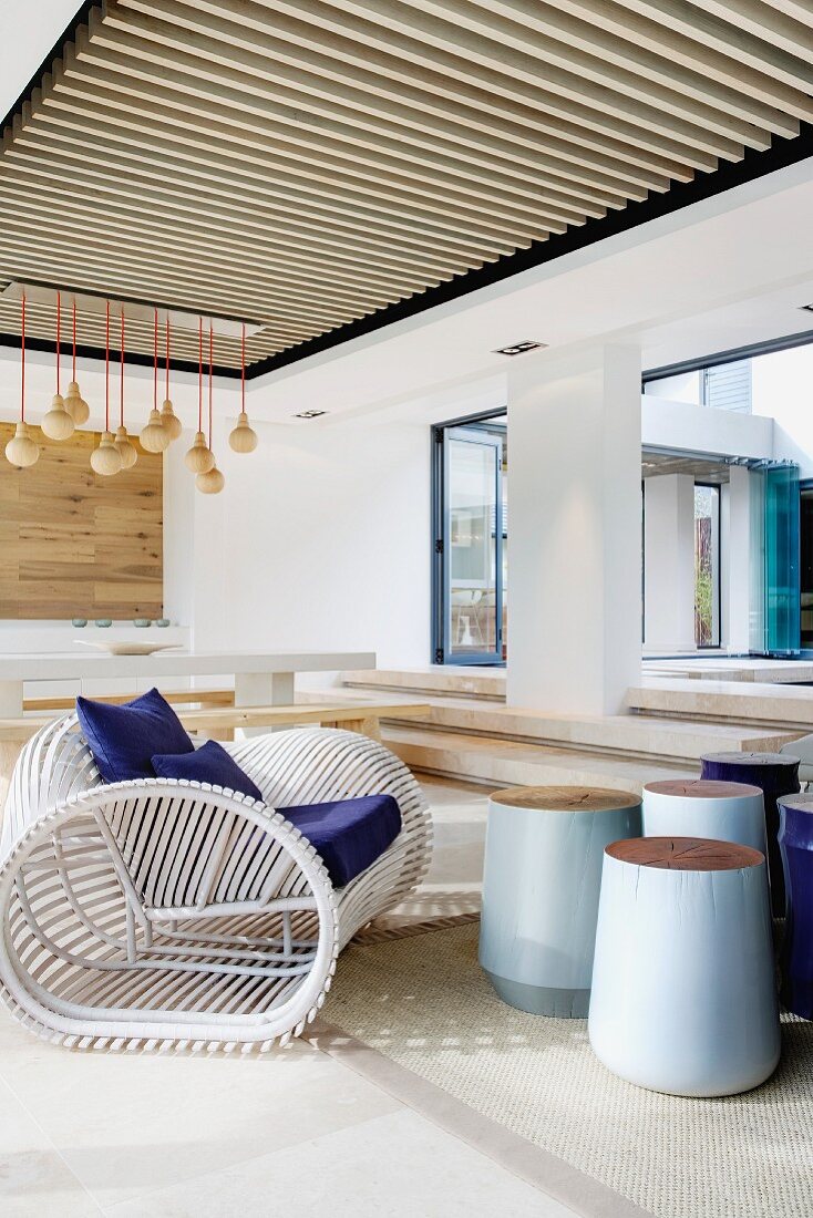 Überdachte Terrasse mit maritimem Sessel aus weiss lackierten Holzstäben