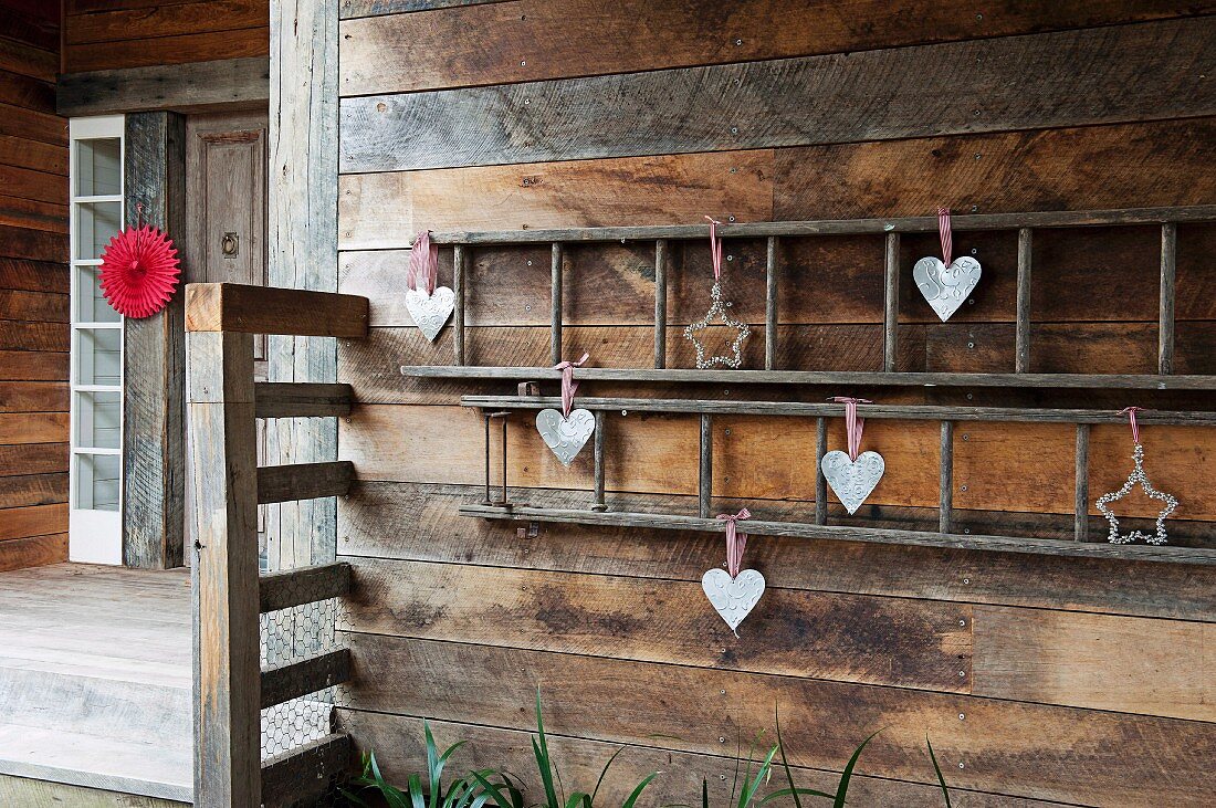 Heart-shaped and star-shaped Christmas decorations on exterior wall of wooden house