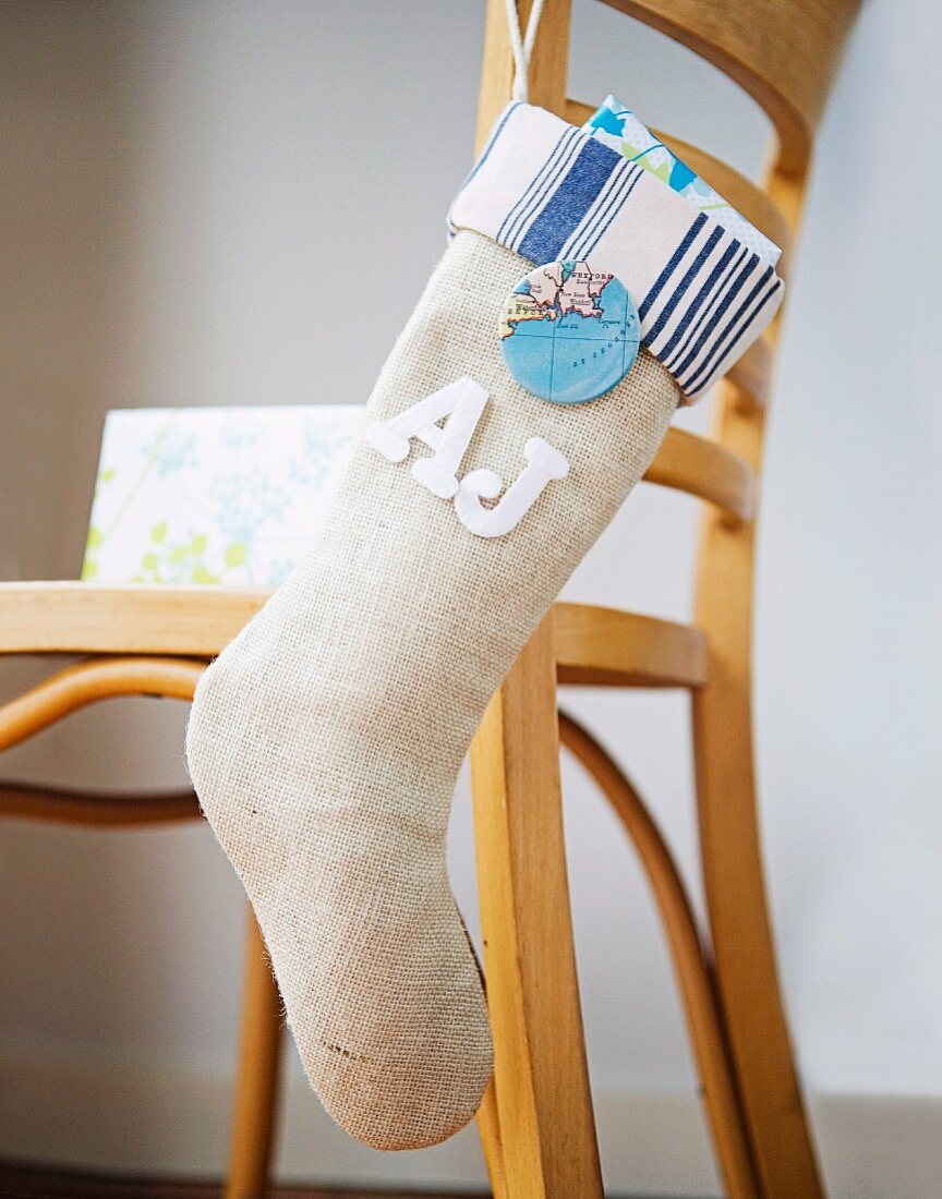 Modern Christmas stocking hanging from back of wooden chair
