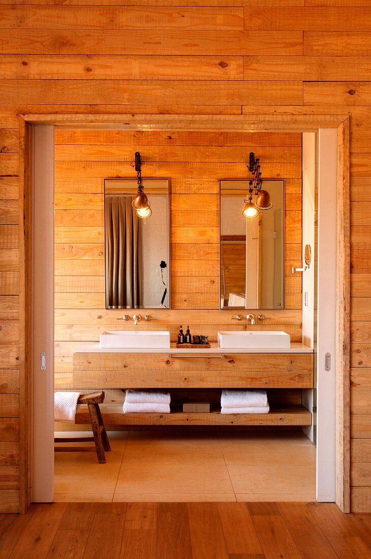 Wood bathroom with two washbasins and long wooden washstand