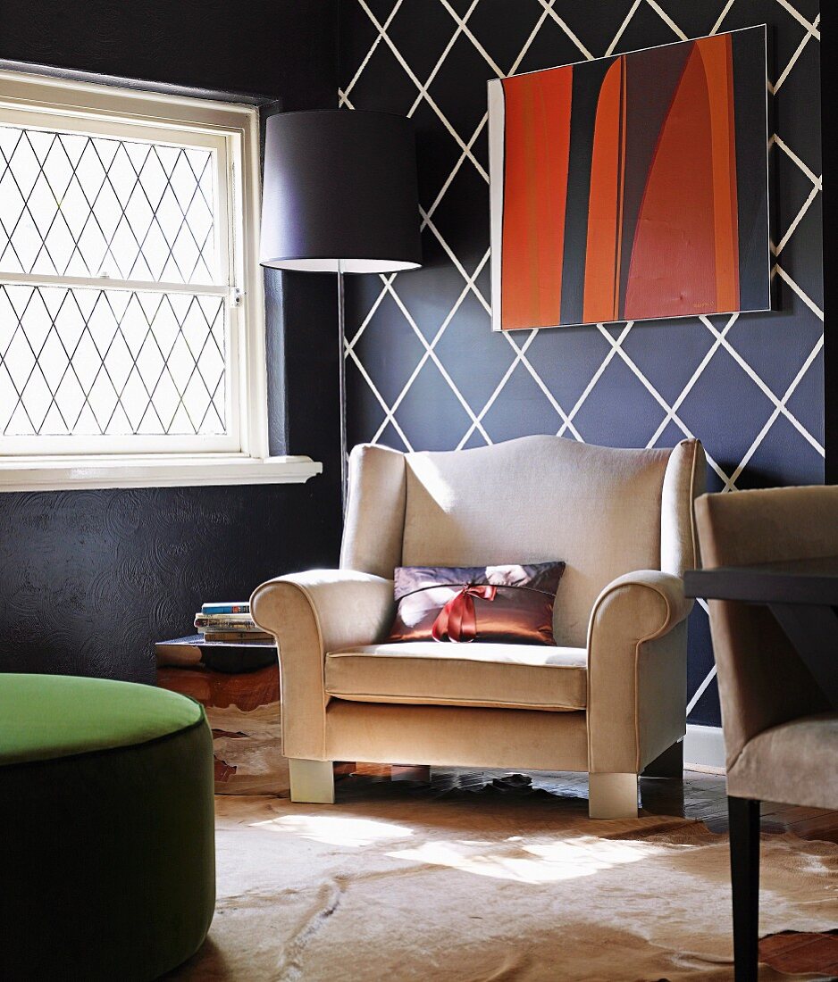 Einladender Polstersessel in Wohnraum mit expressiver schwarzweisser Wandgestaltung