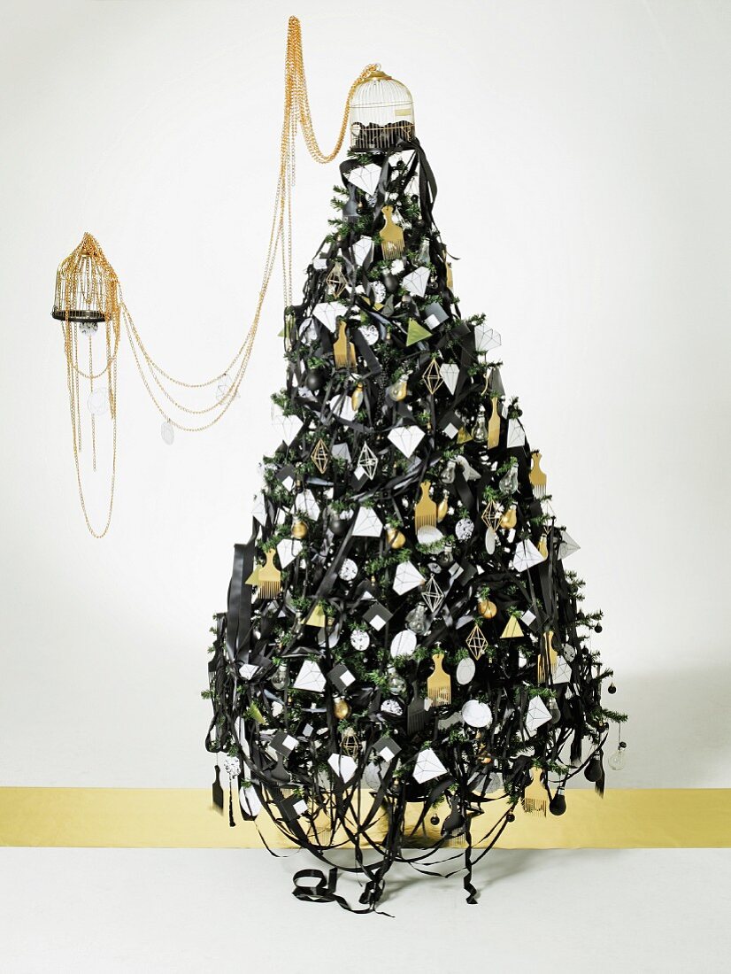 Compact Christmas tree sculpture made from dark ribbons and sheet-metal shapes