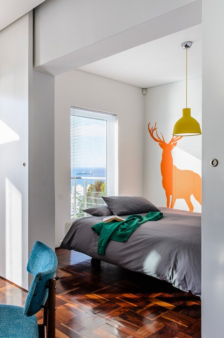 Sleeping area with animal silhouette on wall screened from dining area by sliding door