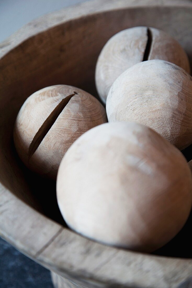 Hand-crafted wooden balls in old wooden bowl