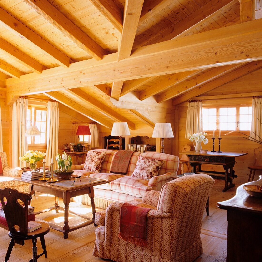 Elegant chalet living room with heavy roof-beam structure and antique furniture