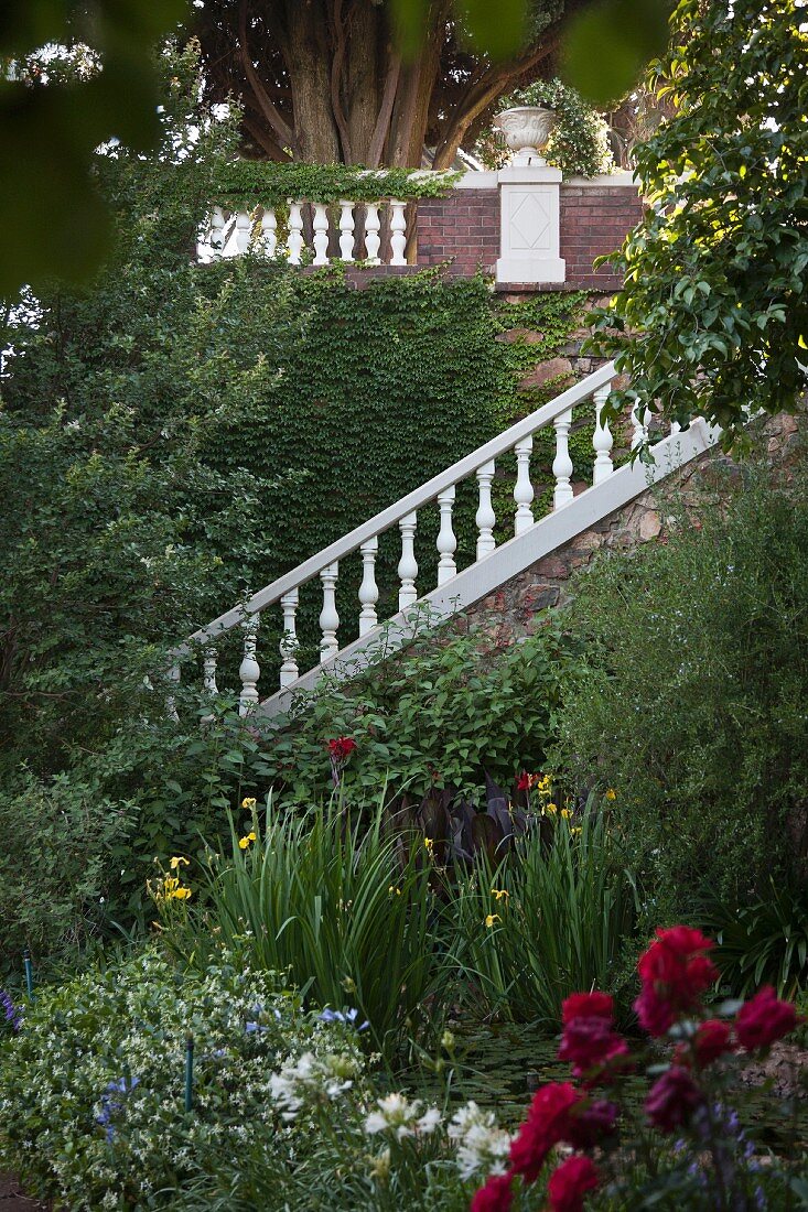 Blühende Gartenanlage mit Treppenaufgang und weisser Stein Balustrade