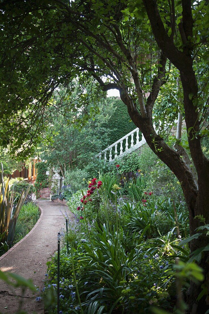 Weg durch blühenden Garten, im Hintergrund Treppe mit weisser Stein Balustrade