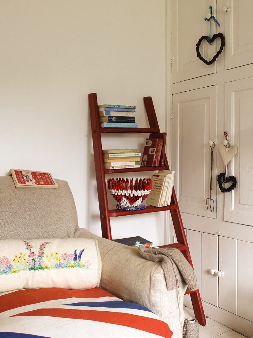 Weisser Einbauschrank und Holzleiter mit Büchern neben einem Sofa