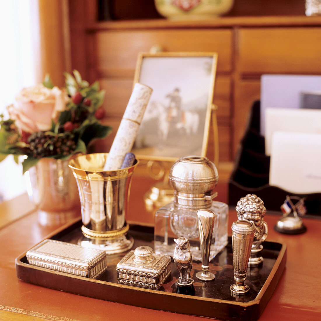 Tablett mit Schatullen und Dekoobjekten aus Silber auf Schreibtisch