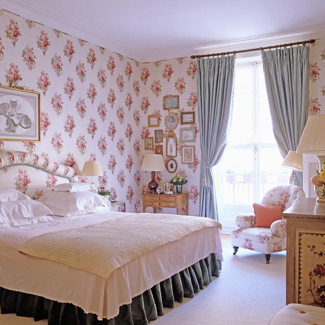 Schlafzimmer mit stoffbezogenen Wänden, Doppelbett & Polstersessel vor Fenster mit Vorhängen