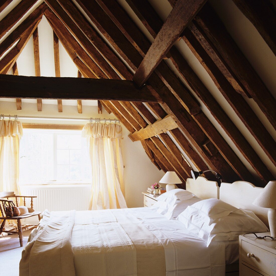Schlafzimmer im Dachgeschoss mit sichtbarer, rustikaler Holzkonstruktion