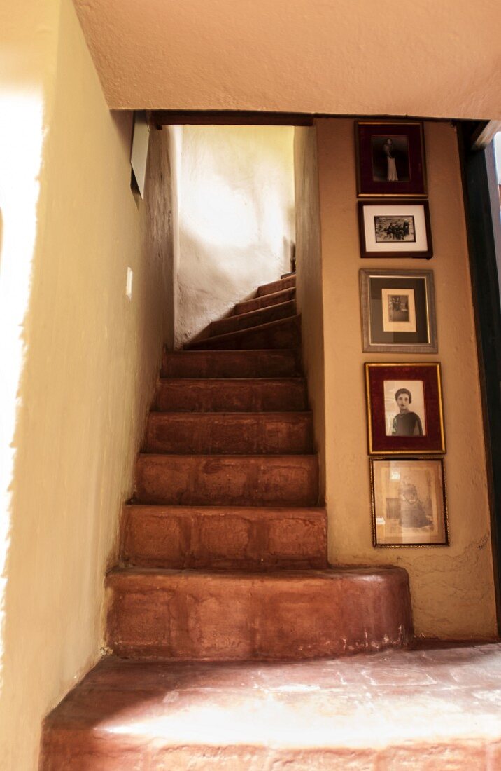 Fotogalerie an der Wand neben Treppenaufgang in einem ecuadorianischen Landhaus