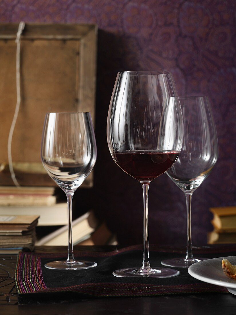 Wine glasses and books in front of a purple background