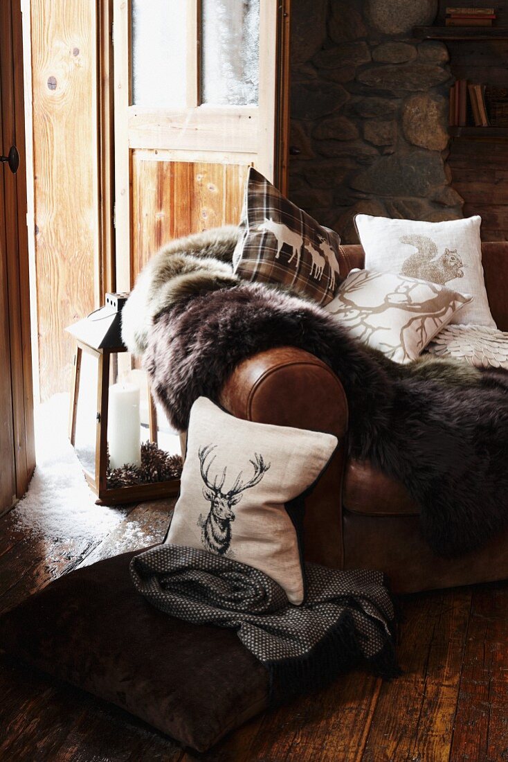 Leather sofa with a throw and pillows in a traditional chalet