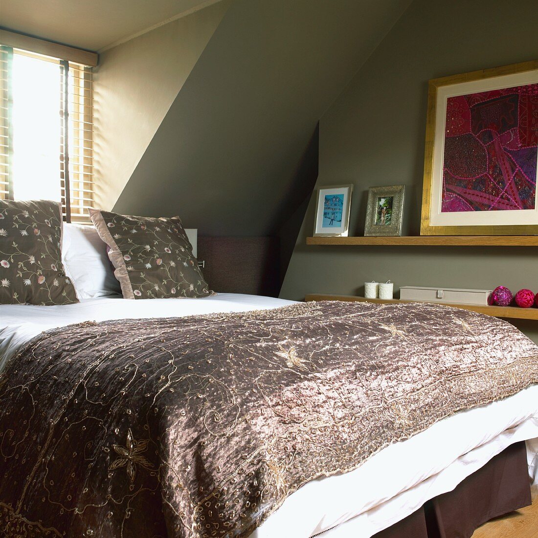 Schlafzimmer im Dachgeschoss mit Fenster, grünen Wänden, Doppelbett, Wandregal und modernen Bildern